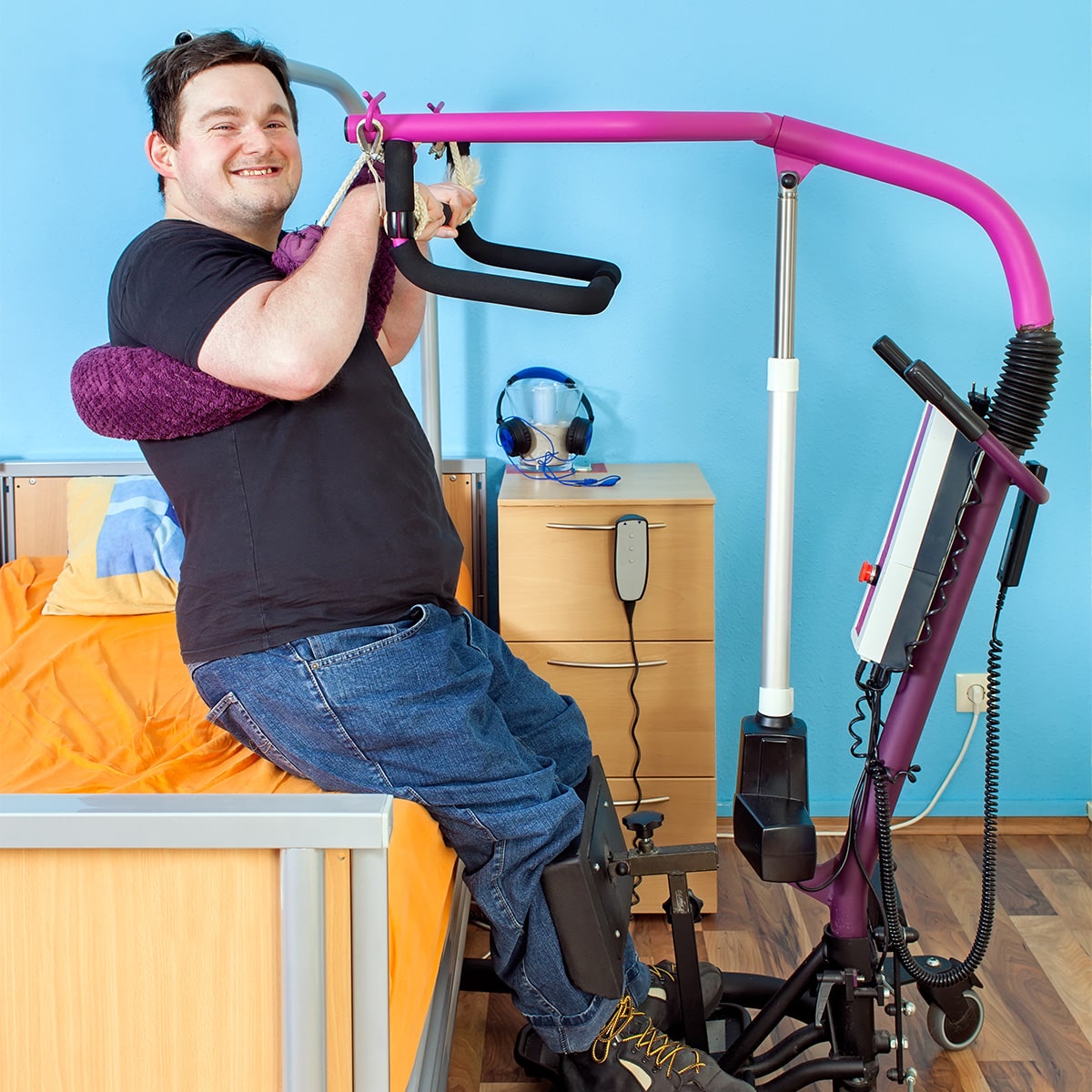 Happy man with disability being safely lifted in a sling hoist, symbolising improved mobility and **disability support** at **Laneways Rehab